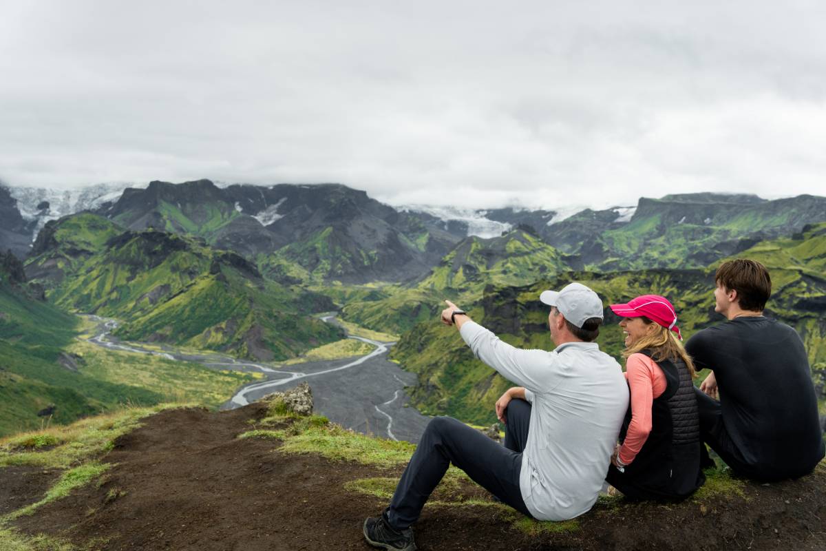 Famille admirant une vallée islandaise verdoyante et les montagnes depuis un point de vue panoramique